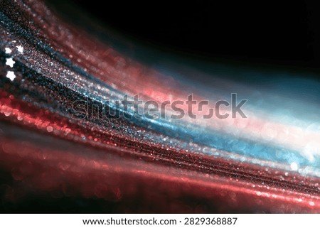 Dynamic abstract background featuring swirling streaks of red, blue, and white light, interspersed with sparkling stars.