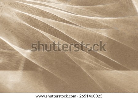 Dynamic abstract beige background, demonstrating flying light glare with colorful reflections, creating an elegant look and texture of delicate fabric. Modern interior of the studio, podium, template.
