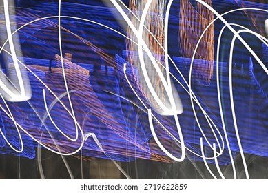 Dynamic abstract image featuring long exposure light trails in vibrant purple and white, creating a sense of movement and energy against a dark background.