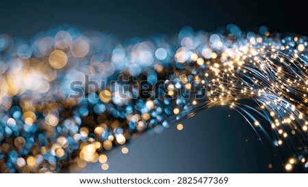 A dynamic abstract image featuring a stream of glowing fiber optic strands with bright bokeh lights in blue and gold hues against a dark background.