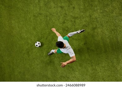 Dynamic aerial view photo of soccer player in mid-motion, preparing to kick the ball on well-maintained field. Concept of professionals sport, competition, tournament, energy, action. Ad - Powered by Shutterstock