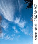 A dynamic atmospheric background showcasing multiple layers of clouds, ranging from dark, heavy masses to bright, wispy formations across a wide sky.