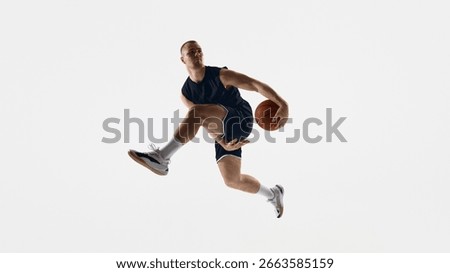 Dynamic basketball player executing a slam dunk in mid-air. Concept of athletic sprint, muscle power, men sports campaigns, and dynamic team energy.