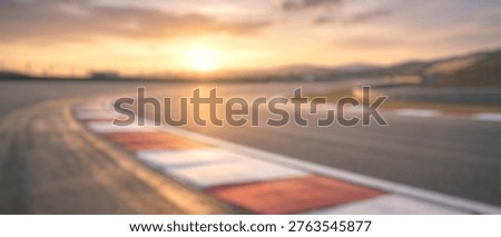 Dynamic blurred motion of an empty racing track at sunset, featuring a vibrant sky and a sense of speed and excitement.