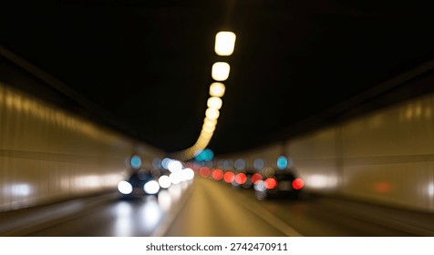 A dynamic, blurred shot capturing the movement of vehicles inside a well-lit tunnel at night. The lights from the cars and the tunnel create streaks of light, emphasizing speed and motion.