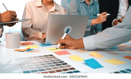 A dynamic brainstorming session featuring a diverse team in a modern office. Participants engage with colorful sticky notes and laptops to develop innovative ideas and strategies. SACTR