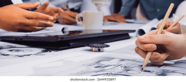 A dynamic brainstorming session featuring hands engaged in sketching and discussing designs with digital tools in a modern office setup, showcasing teamwork and creativity. SACTR