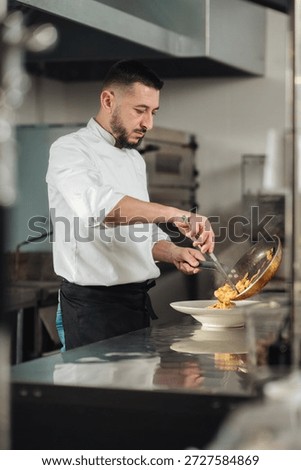 Dynamic chef skillfully cooks amidst vibrant flames and sizzling oil