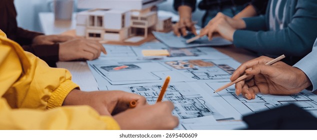 A dynamic collaborative design session where architects and clients engage in sketching blueprints and models for innovative building projects, showcasing teamwork. SACTR