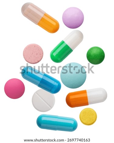 Dynamic composition of assorted multicolored pharmaceutical pills, capsules, and tablets captured floating and isolated on white.