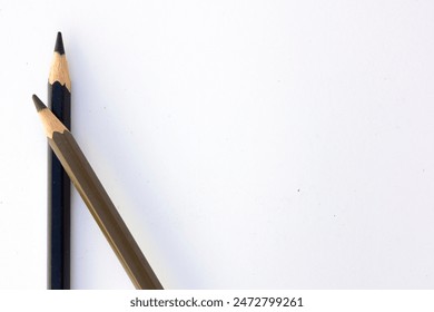 The dynamic diagonal arrangement of two colored pencils draw the eye across the image, leaving ample negative space for potential text or additional graphic elements.  - Powered by Shutterstock