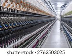 Dynamic diagonal composition showing rows of spinning machines and continuous yarn production in an industrial textile environment.