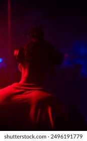 A dynamic and energetic scene featuring DJs mixing music on stage, illuminated by vibrant lights and special effects. The crowd below is a sea of people dancing, enjoying the rhythm.