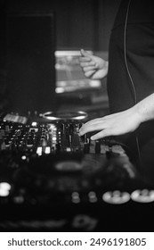 A dynamic and energetic scene featuring DJs mixing music on stage, illuminated by vibrant lights and special effects. The crowd below is a sea of people dancing, enjoying the rhythm.