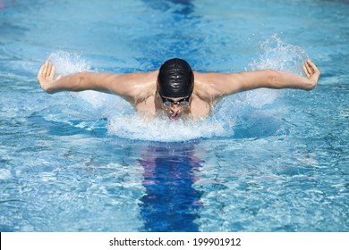  dynamic and fit swimmer in cap breathing performing the butterfly stroke  in swimming pool 