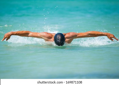 Dynamic And Fit Swimmer Man Swimming The Butterfly Stroke In Ocean