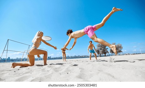 Dynamic game. Positive and active young people, friends gathering on beach by the river and playing energetic frisbee game. Concept of sport, summer activity, leisure games, friendship - Powered by Shutterstock