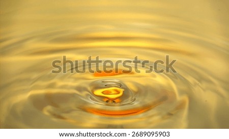 Dynamic Golden Liquid Surface with Concentric Ripple Effect and Abstract Yellow Water Texture Background.