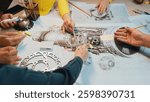 A dynamic group collaboration captures hands engaged in drawing details of a jet engine, showcasing teamwork and creativity in engineering design projects. SACTR