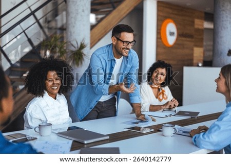 A dynamic group of colleagues communicating ideas in a modern office space, fostering teamwork and innovation.