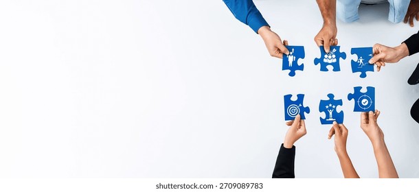 A dynamic group of hands working together to assemble a blue puzzle featuring creative symbols, showcasing teamwork and collaboration in a modern, minimalist setting. Amity