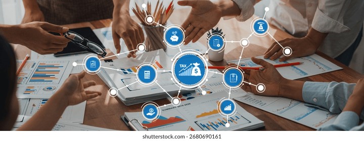 A dynamic group of professionals engages in a collaborative tax planning session, surrounded by financial charts and documents on a wooden desk. Amity