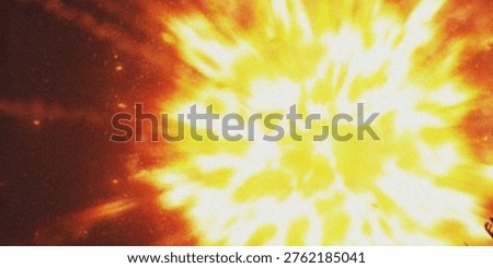 A dynamic image of a bright orange and yellow explosion set against a dark background, showcasing a burst of radiant light with varying shades of warm colors and texture