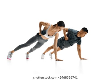 Dynamic image of fit man and woman performing plank row exercise with dumbbells against white studio background. Concept of people in sport, healthy lifestyle, teamwork, motivation. Ad - Powered by Shutterstock