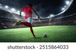 Dynamic image of man, soccer player in red uniform, kicking ball on well lit stadium field at night. Energy and focus. 3D render of stadium. Concept of sport, competition, tournament, games, event