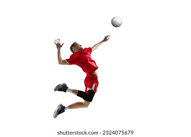 Imagen dinámica de un joven deportista, jugador profesional de voleibol con uniforme rojo en movimiento, golpeando a la pelota con fondo de estudio blanco. Concepto de deporte, estilo de vida activo, salud, dinámica, juegos y