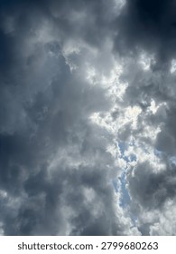 Dynamic interplay of heavy gray clouds and sudden shafts of ethereal light