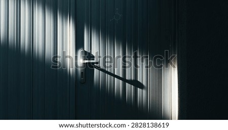 Dynamic interplay of light and shadow creates an abstract pattern on a textured, vertical surface.