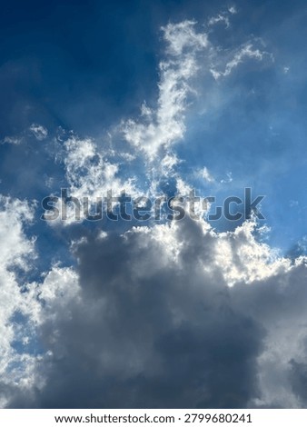 Dynamic interplay of sunlit cumulus formations against an expansive sapphire firmament