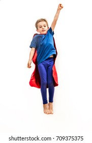 Dynamic Isolated Kid Reaching High Like A Powerful Superhero, Flying With An Arm Raised, Pretending Reaching Something Over White Background