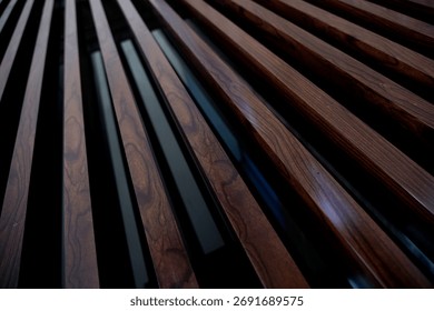 Dynamic low-angle perspective of dark brown fluted wood paneling. Close-up of rich wood grain texture. Abstract background