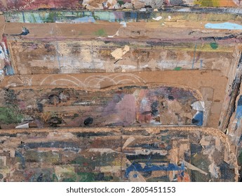 Dynamic macro texture of layered paint splatters and worn cardboard creates a rich abstract polychromatic background
