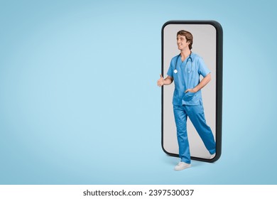 Dynamic male nurse in blue scrubs appears to step out from the screen of a giant smartphone, illustrating telemedicine concepts, against a complementary blue background - Powered by Shutterstock