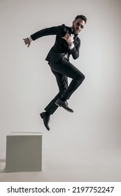 Dynamic Man Wearing Tuxedo Illustrating Concept Of New Life, Leaving Old Things Behind And Embracing Change On Grey Background