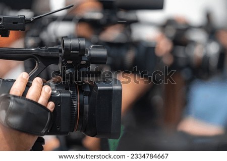 Dynamic media presence as TV cameras capture the energy of an outdoor press conference, delivering comprehensive coverage in an engaging setting