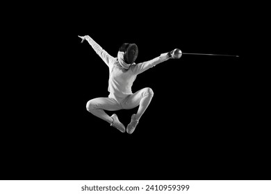 Dynamic mid-air snapshot of swift motion of female fencer's blade, dynamic lines and angles of her body during fight against black studio background. Concept of professional sport, championship. Ad - Powered by Shutterstock