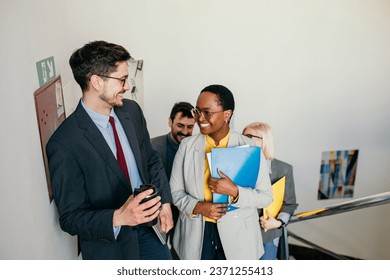 A dynamic mix of businesspeople, representing diversity in gender, race, and age, converge outside a sleek office entrance, signaling the start of an important meeting - Powered by Shutterstock