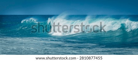 Dynamic ocean waves break with spray against the coast under a blue sky, Fuerteventura, Canary Islands, Spain