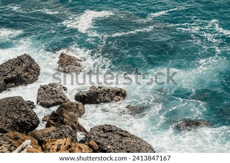 Dynamic ocean waves hitting jagged coastal rocks