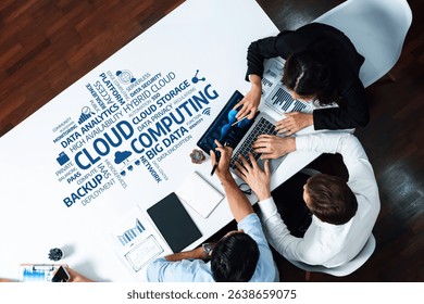 A dynamic overhead view of professionals collaborating in a modern workspace, focusing on cloud computing and data analysis with various technology concepts visually presented. Amity - Powered by Shutterstock - Get 15% off with code: PIKWIZARD15