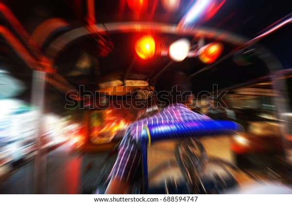 Dynamic perspective and long time\
exposure inside a Tuk tuk vehicle on Road in Bangkok,\
Thailand
