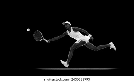 Dynamic photo of tennis player jumping to hit overhead shot in motion against black studio background. Monochrome filter. Concept of sport, active lifestyles, tournaments and events, energy, movement. - Powered by Shutterstock