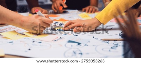 A dynamic scene captures a diverse group engaged in a brainstorming session, showcasing creativity and teamwork as they use colorful sticky notes and markers on a large paper layout. SACTR
