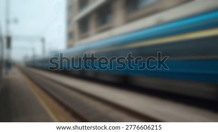 A dynamic shot capturing the blurred movement of a high-speed train as it swiftly passes through a station, conveying speed and modern transportation.