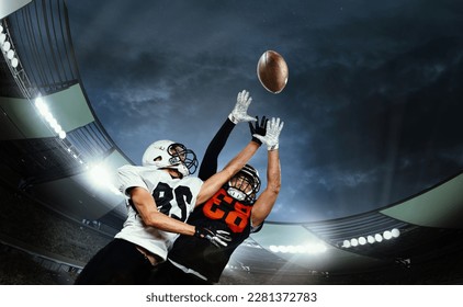 Dynamic shot of male sportsmen, professional american football players during game, catching ball. Open air 3D stadium in evening. Concept of sport, competition, action and motion, game, cup. - Powered by Shutterstock