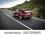 Dynamic shot of a red luxury SUV cruising through a winding countryside road, showcasing its bold design, agility, and modern engineering excellence.